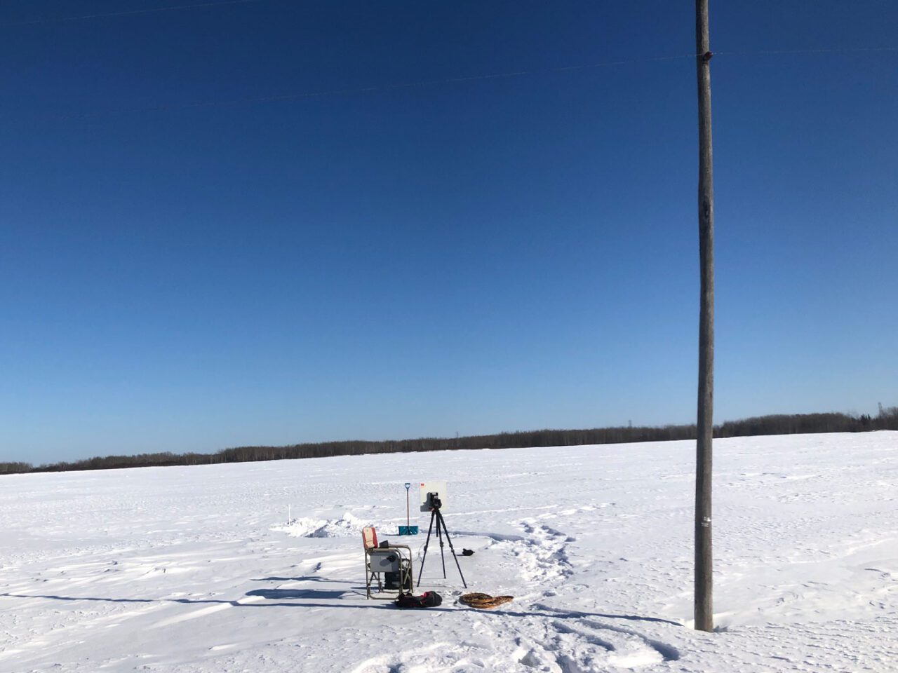 chair and equipment on a vast plain of snow, probably a frozen pond.