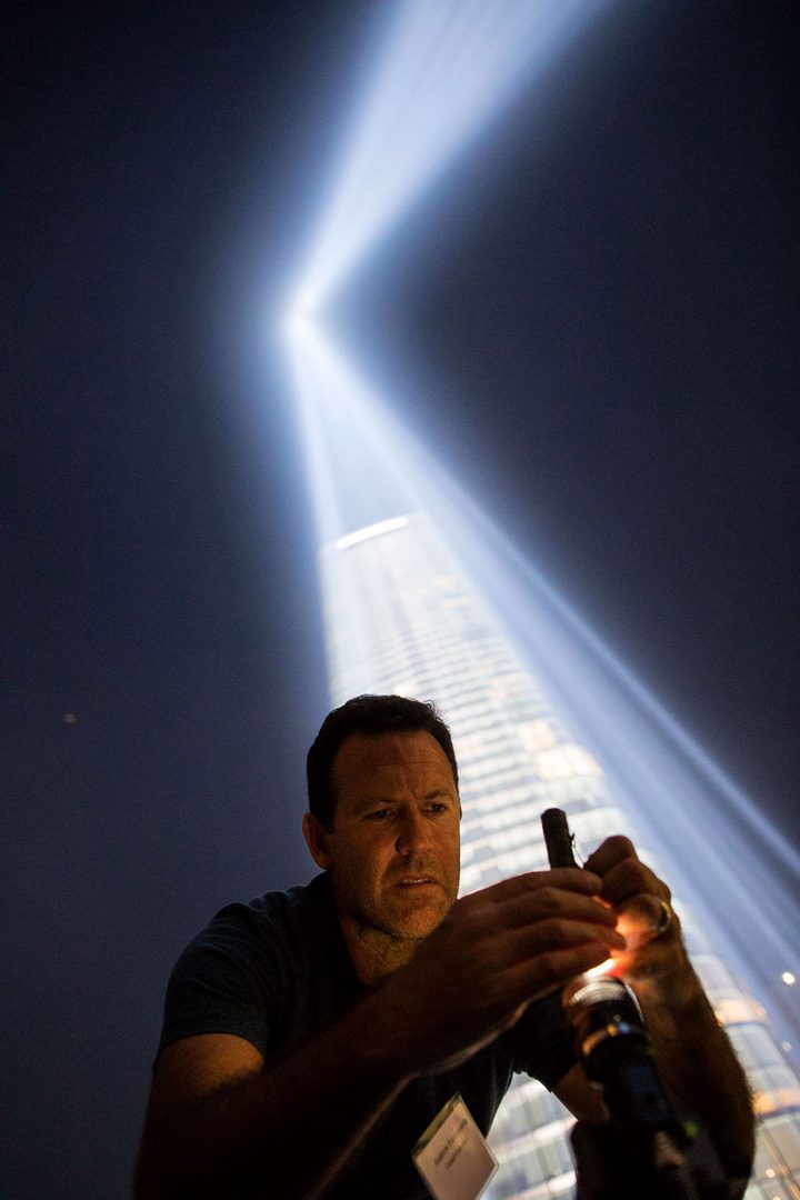 Andrew Farnsworth adjusts a camera used to document bird densities in the light beams. Photo by Ben Norman.