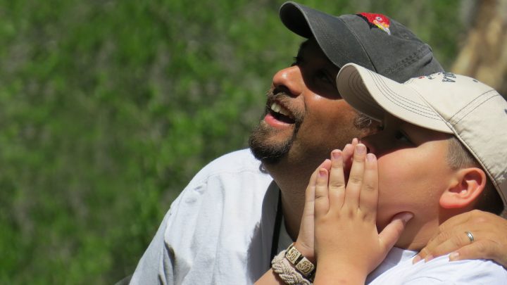 A father and son see their first Pileated Woodpecker together in Acadia National Park.