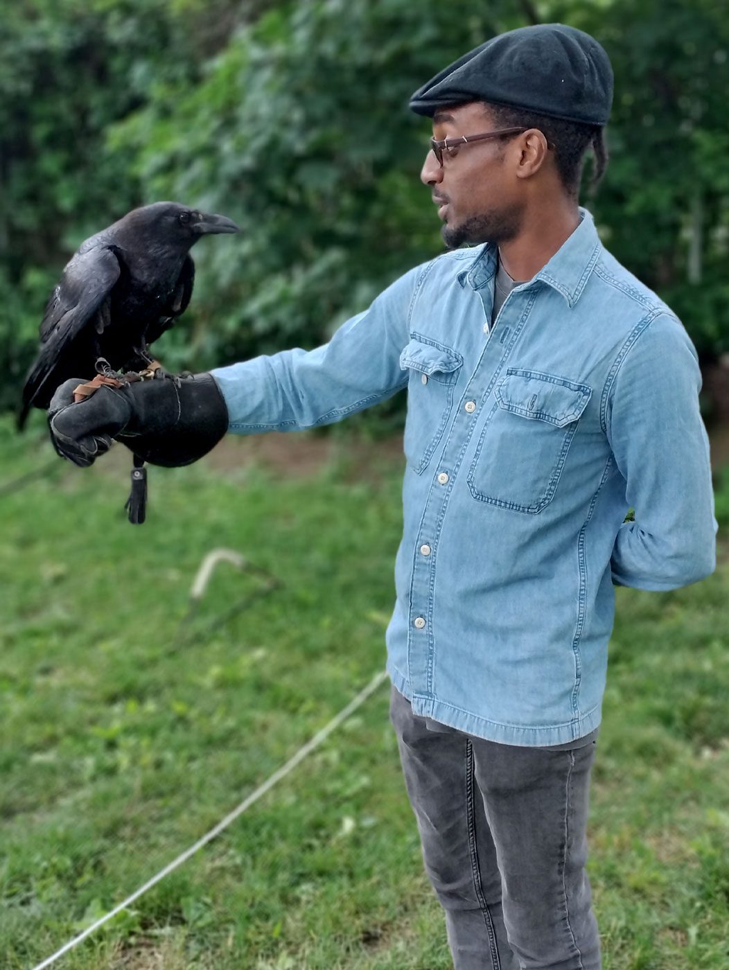 A man holds a black bird.