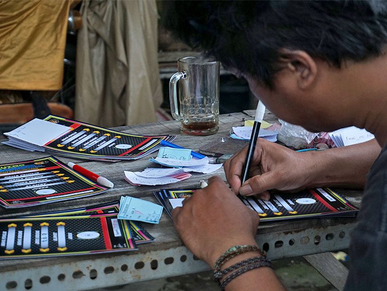 A man fills out cards at a table.